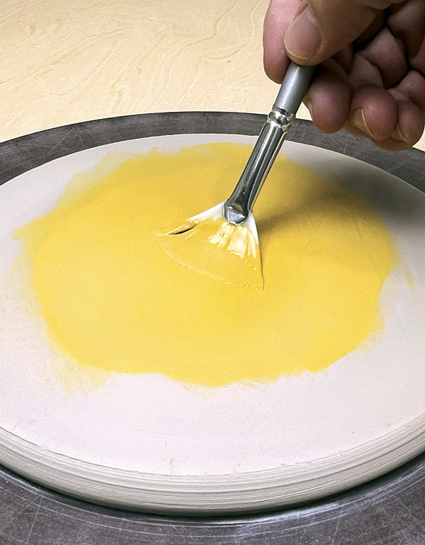 2 Brush two coats of underglaze over the center of the disk.