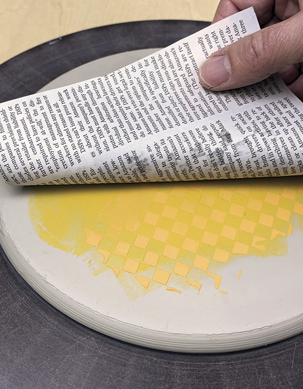 6 Place dry newsprint over the dry raised design and roll the surface flat.