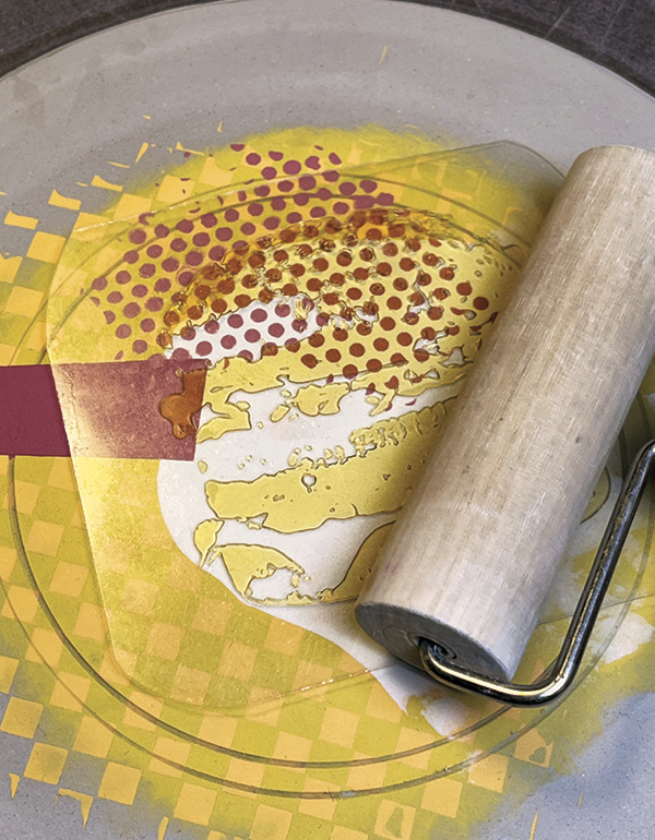 14 Position the print plate on the disk and roll the design into the clay surface.