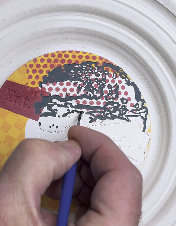 27 Apply black underglaze into the impressed image of the hamburger.