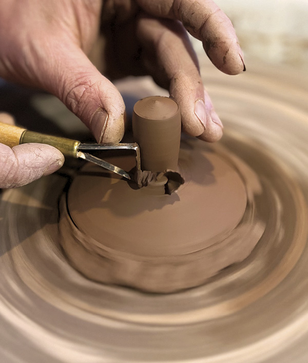 9 Throw and trim a tall, slender knob from the excess hump clay. Use a needle tool to trim it from the hump.