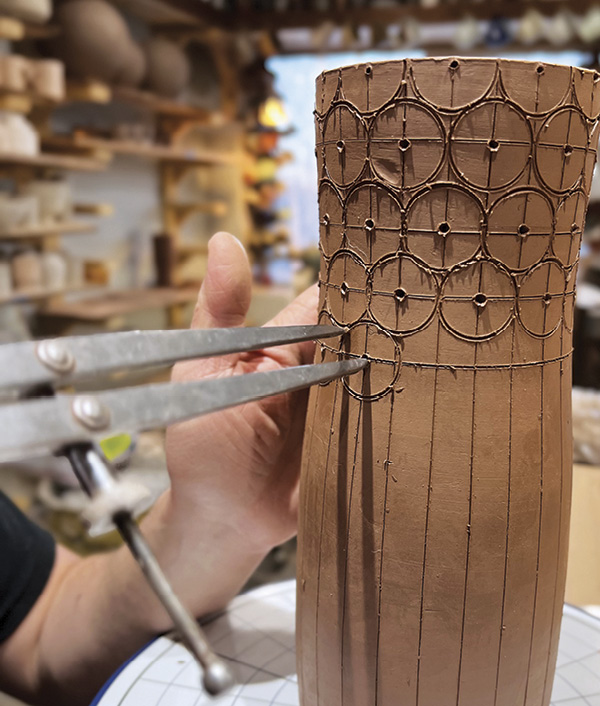 12 Set a spring divider to the width between the vertical lines and draw half circles in rows across the top of the pot.