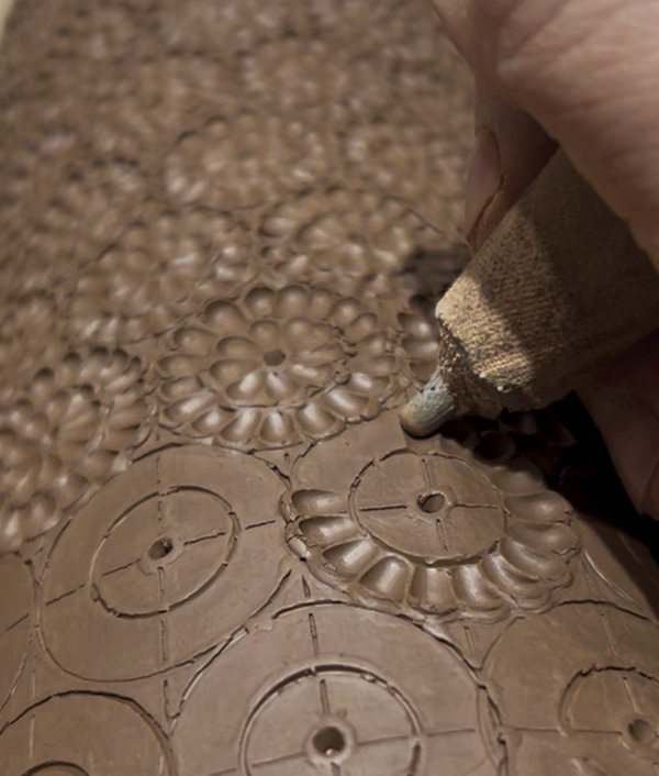 13 Plow individual petals by pressing into the soft clay with a blunt edge. Move the tool outward from the center point.