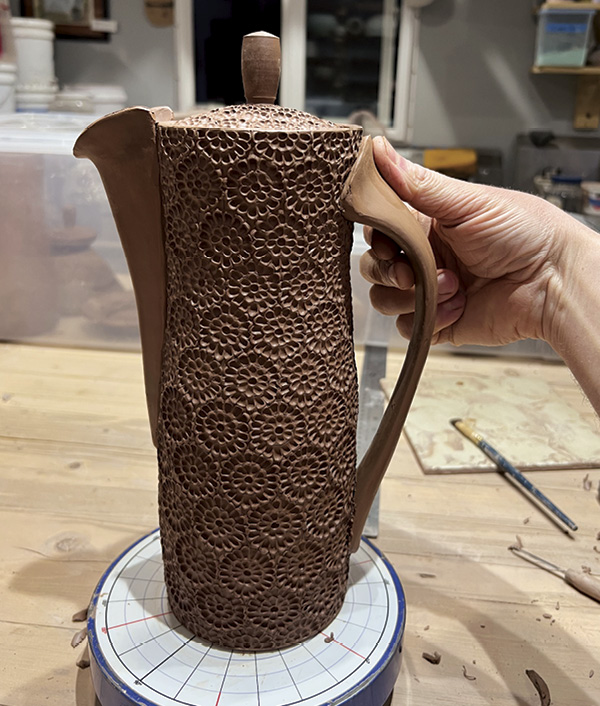 18 Score, slip, and join the handles to the pot and cone by working the clay into the pot with your thumbs.