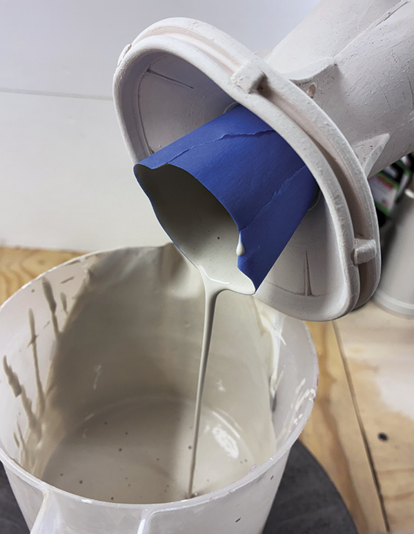 17 Continue to use the blue tape as a funnel to pour glaze out of the vase.