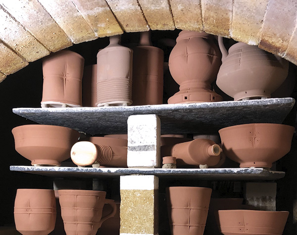 2 Work, prepared with Laterite and Cedar Heights Redart Slips for reduction-cooled wood firing, loaded in the train kiln.