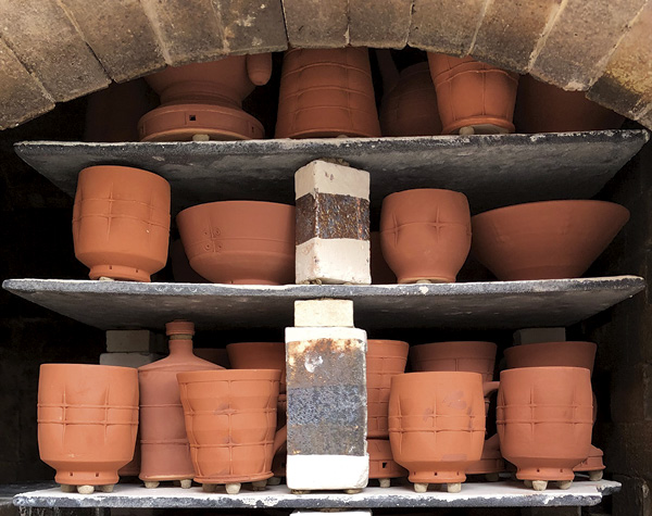 4 Work, prepared with Laterite slips for reduction-cooled wood firing, loaded in the train kiln.