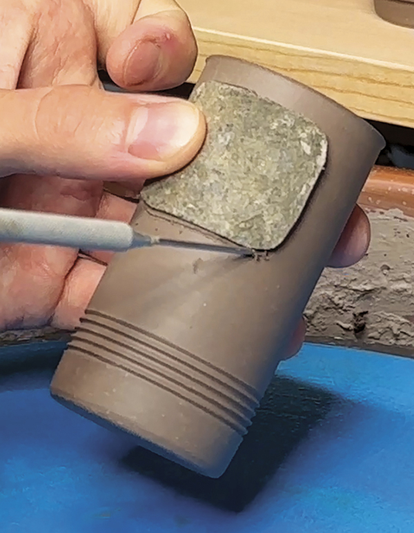 6 Using a tar-paper guide, cut a hole in the first cylinder about ¼ inch from the top.