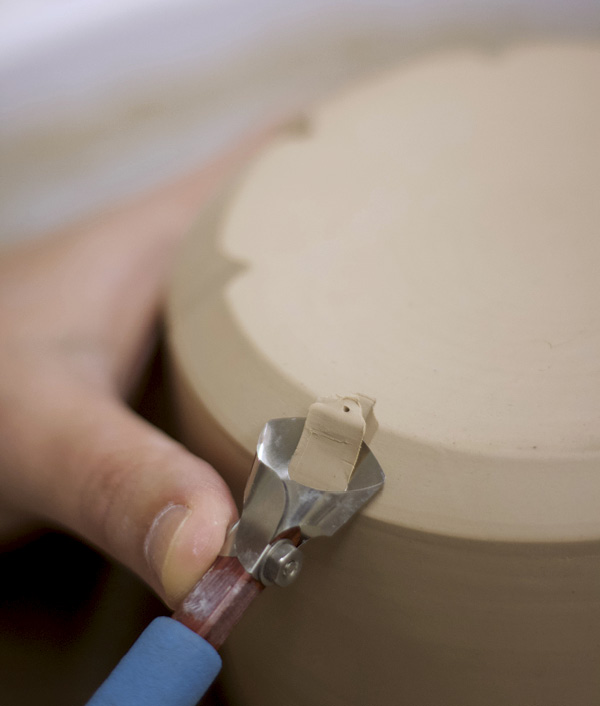 9 Use a fluting tool to carve through your first marks along the beveled edge of the base.