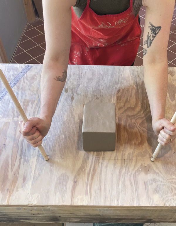 1 Rest dowels on the surface of a table, keeping the cutting wire taught.