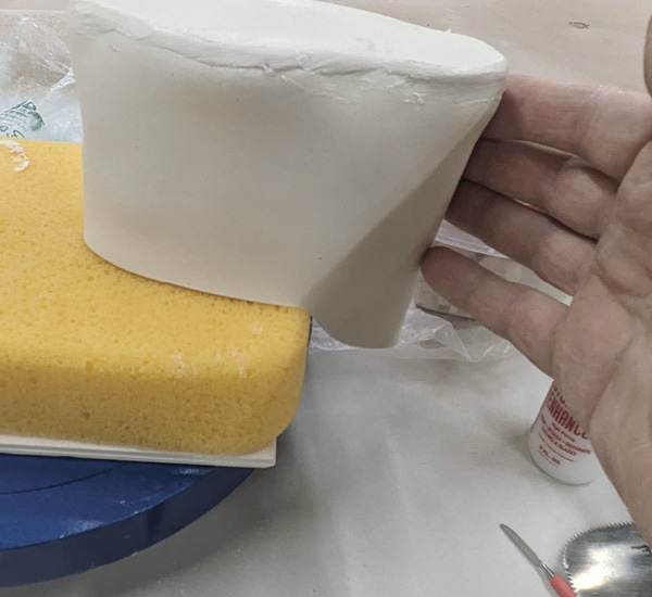 4 Flip the piece onto a sponge so the spout hangs over the edge.