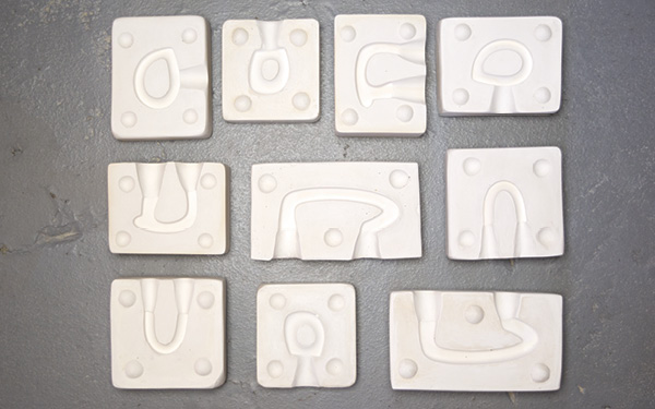 8 Variation of handles shown in one half of two-part plaster molds. The options are endless.