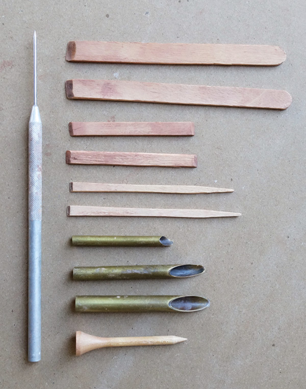 3 Tools used for forming ocarinas: needle tool, beveled craft sticks, hole cutters, golf tee.