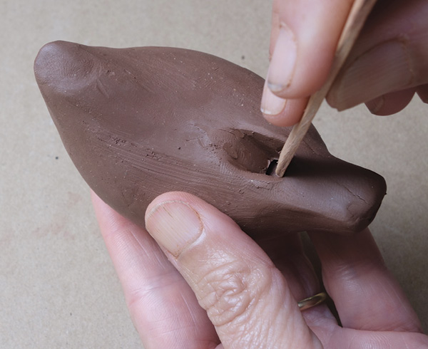 11 Push clay plugs away with a craft stick and clear the windway. Blow into the ocarina to check it produces a tone.