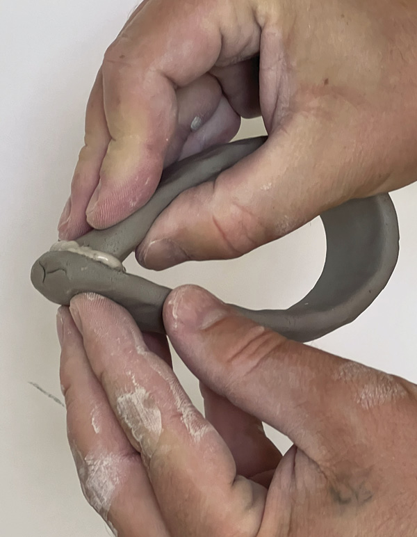 10 Turn a coil back on itself to create a handle. Score, slip, then compress the join.