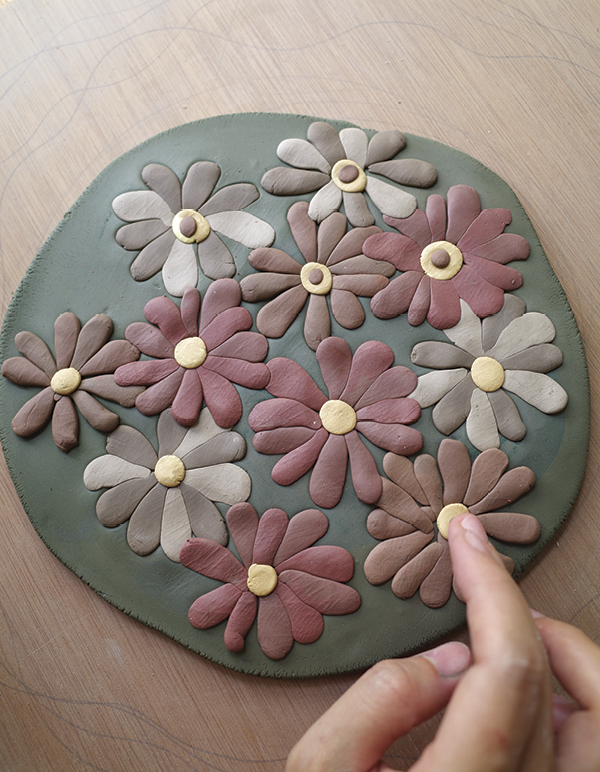 3 Place petal shapes of different colors and press them gently with a finger.
