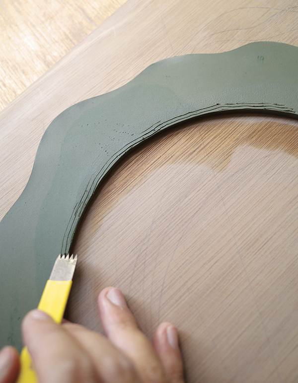 8 Smooth the edges, then score the back where the mirror will later be attached.