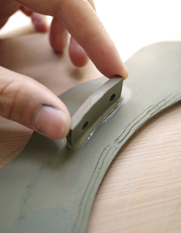 10 Attach the tabs at evenly spaced intervals to the back of the frame.