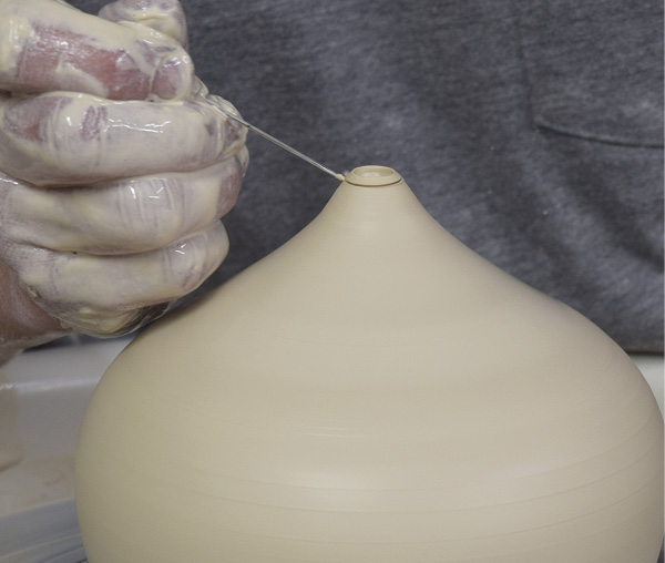 3 Hold a needle tool at the angle shown, and cut the tip off the opening.