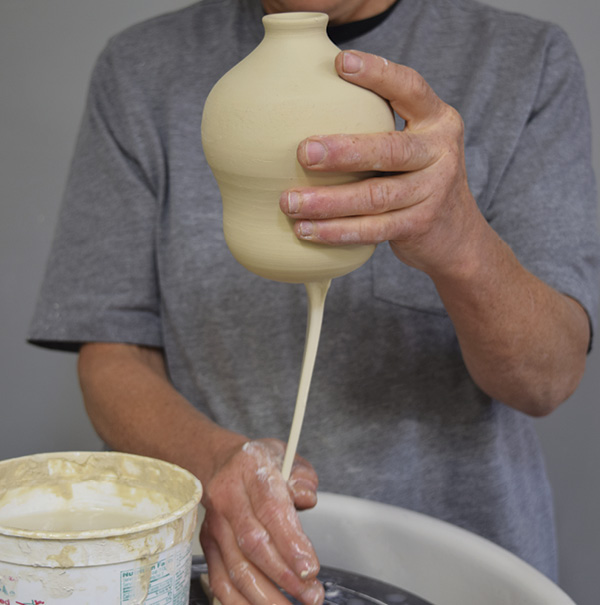 7 Wetting your hand frequently, pull the handle until it is long and thin enough to loop gracefully.