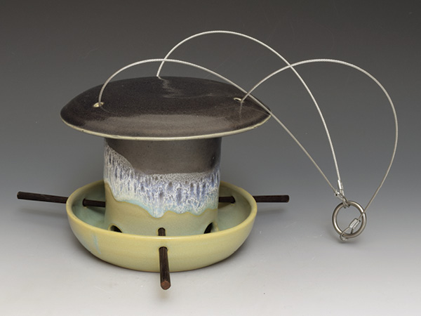 Sumi von Dassow’s bird feeder 6 in. (15.2 cm) in height, wheel-thrown white stoneware, fired in oxidation to cone 6, stainless-steel cable hanger, chopsticks perches, 2023.