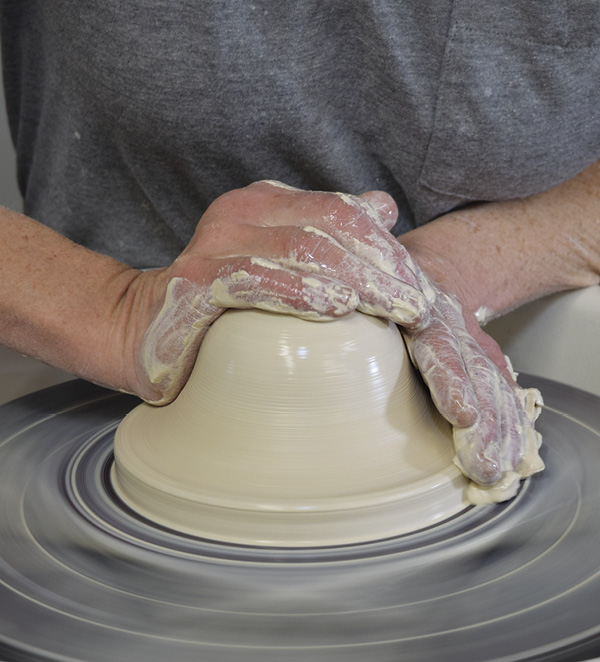 1 Center 3 lbs (1.4 kg) of clay and use the heel of your hand to push out the bottom edge of the mound as if you are going to throw a planter.