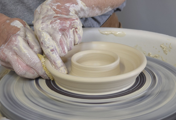 8 Now, pull out the clay at the edge of the pancake to create the overhanging roof.