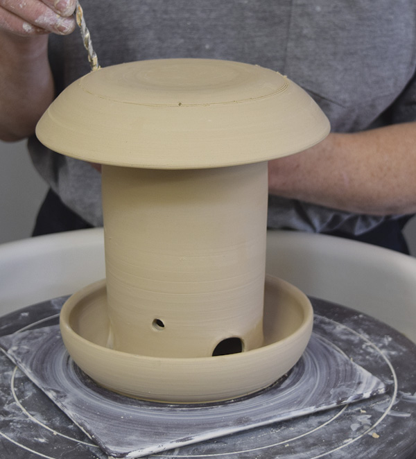 13 Place the lid on the feeder and drill holes. They should line up above the holes in the top of the feeder. Thread a ¹/₁₆-inch (0.16-cm) cable or cord through the holes in the top of the feeder and through the holes in the lid to hang  the feeder.