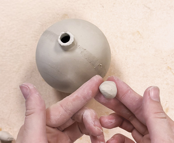 2 Use a small, triangle shaped nub of soft clay to cap the ornament at the pouring hole.