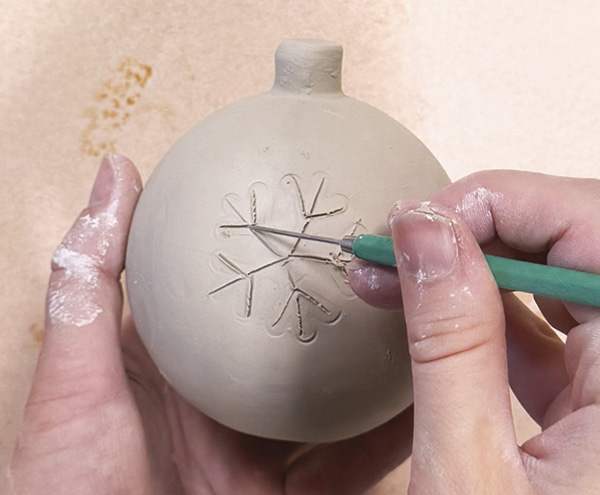 3 Lightly stamp a design onto the surface, then scratch over it with a needle tool.