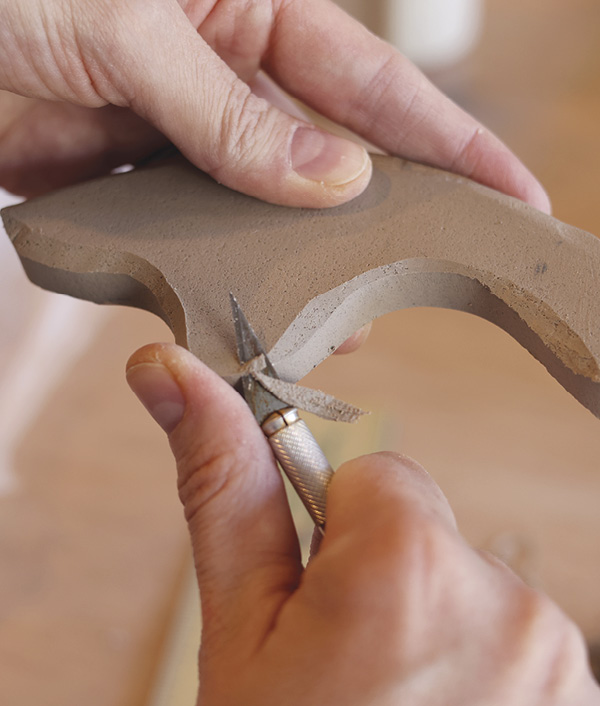6 Trim the edges with a knife to refine the leather-hard handles.
