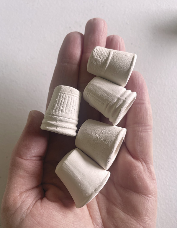 12 Greenware thimbles with the mold seams removed.