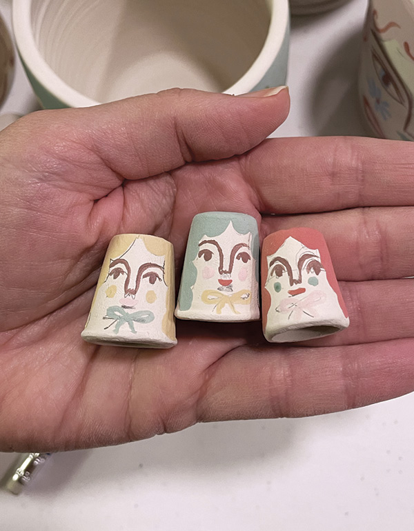 13 Paint tiny faces and details onto the thimbles to match the mugs.