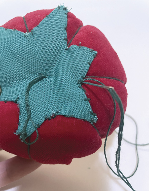 19 Fold the edges under, blind stitch it to the top, then create a looped stem.