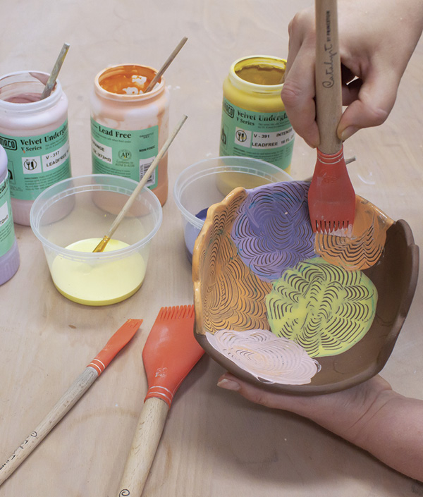 11 Brush underglaze on to the bowl then gently run a silicone comb through the designs to create texture.