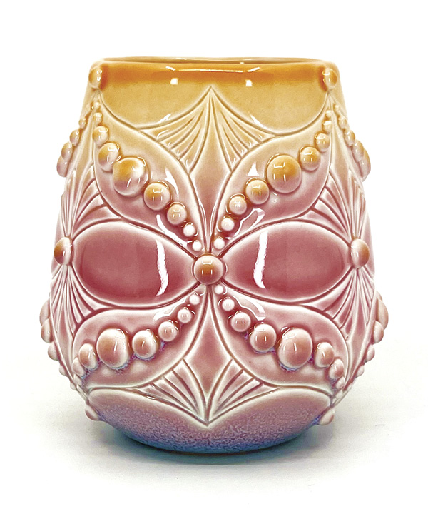 Ali Schorman’s Orange, pink, and purple wine cup, 4¼ in. (11 cm) in height, slip-cast in Laguna Glacier white casting slip, hand carved, slip trailed, fired to cone 5 in oxidation, 2023.