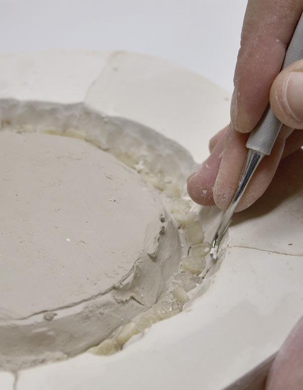 6 Use a metal scraping tool to shave down plaster and get rid of undercuts.