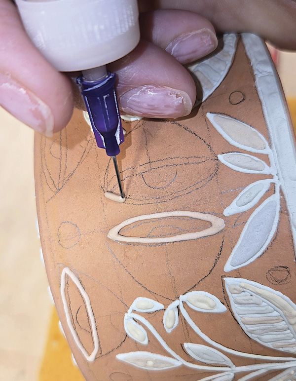 11 Outline the larger parts of the flower design with a slip trailer.