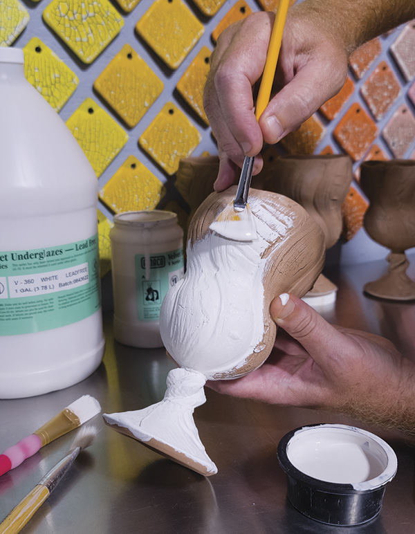 2 Apply two coats of white underglaze to bisqueware.