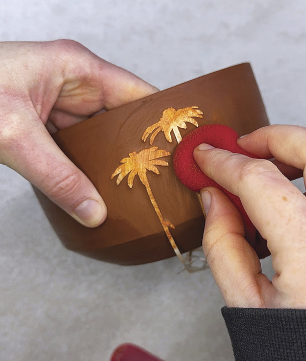 3 Remove clay with a wet sponge around the stencil to create a raised surface.