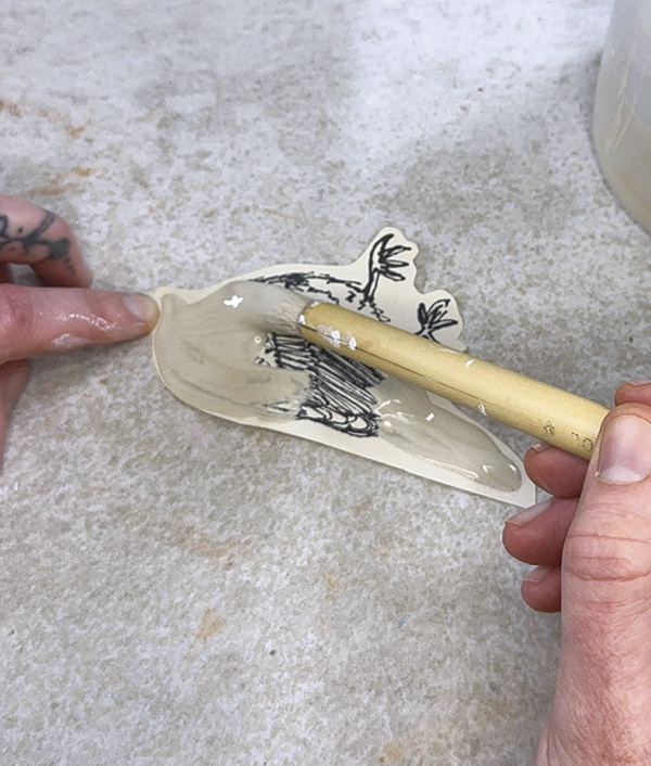 15 Apply a thick coat of white slip or underglaze over the transfer image.