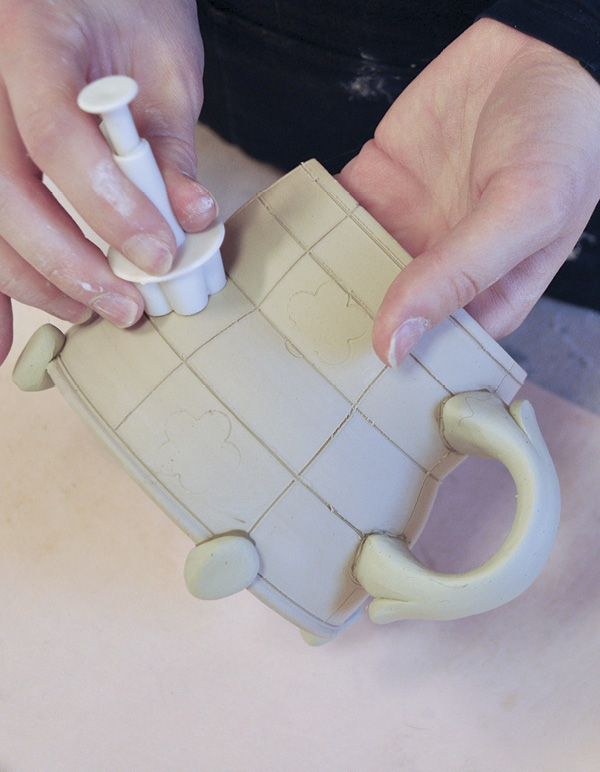5 Use a stamp cutter to mark where to scrore and slip the clay additions.