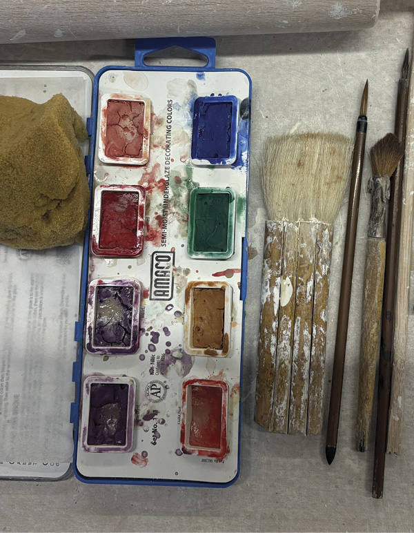 13 Glazing tools: assorted brushes, underglazes, and a sponge.