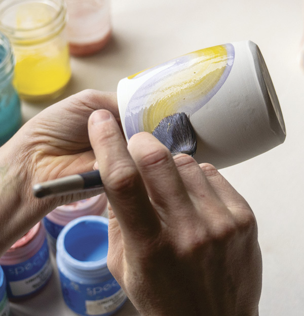 7 Apply a stroke of yellow underglaze on purple stain, then wash your brush.