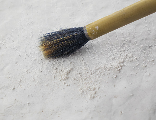 2 Use a soft brush to remove the crumbs that accumulate along the edge of a drawn line.