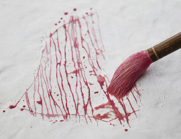 3 Brush a contrasting color of thin slip or underglaze over the line. Allow the color to sink into the carved lines.