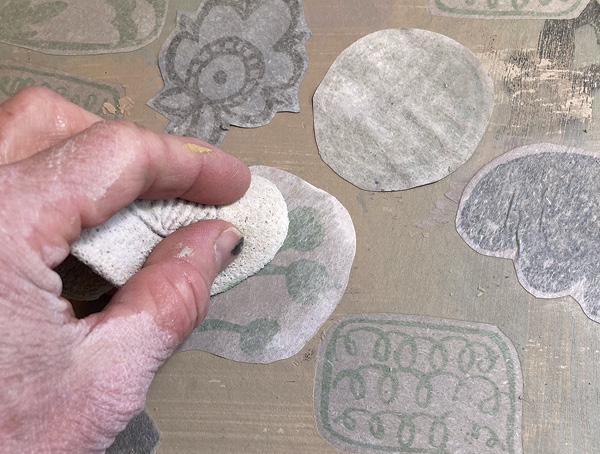 7 Place the floof, wet-slip side down, onto the clay slab. Gently press the floof down on the clay with a damp sponge.