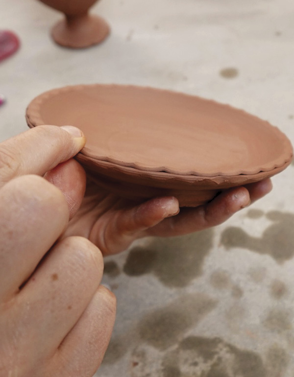 6 Pinch the split rim of the saucer creating a textured edge.