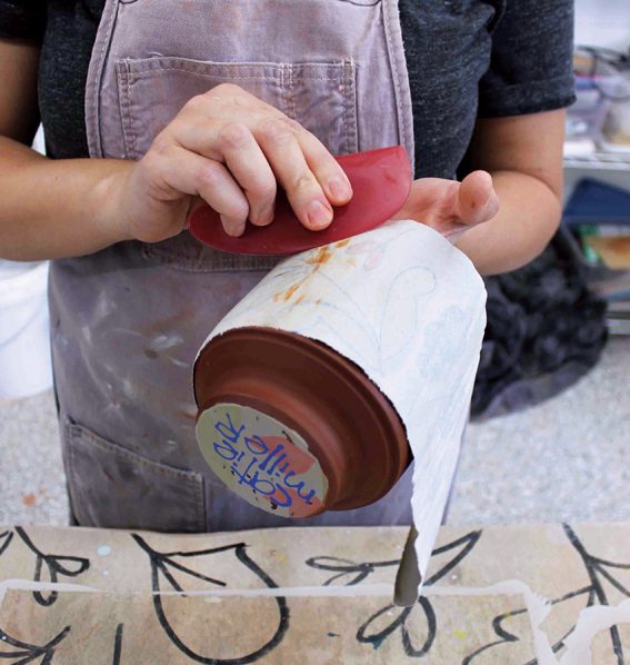 9 Gently roll over the image with a pony roller to adhere any parts of the slip design that aren’t fully stuck to the clay.