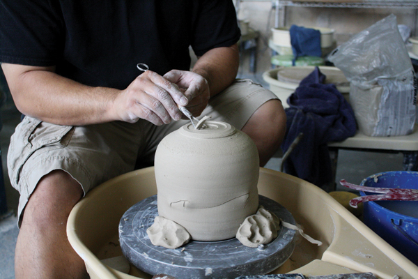 10 Center the upside-down jar on the wheel, secure it with clay, then trim the bottom.
